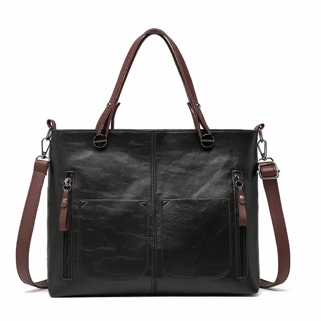 Black PU leather crossbody tote with twin front pockets, zip pulls, and shoulder strap.