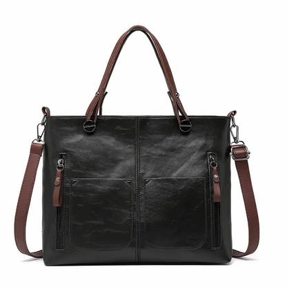 Black PU leather crossbody tote with twin front pockets, zip pulls, and shoulder strap.