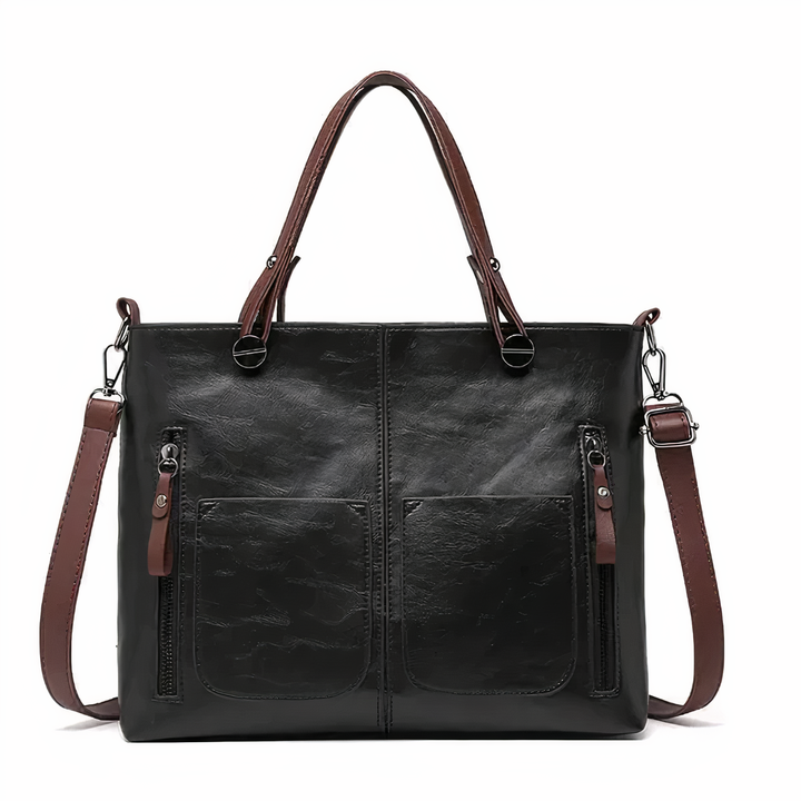 Black PU leather crossbody tote with twin front pockets, zip pulls, and shoulder strap.