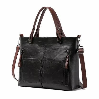 Black PU leather crossbody tote with twin front pockets, top handles, and side zip pockets.