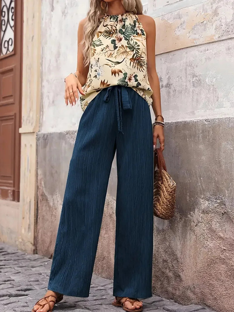 Two-piece set with sleeveless floral blouse and dark blue wide-leg drawstring pants