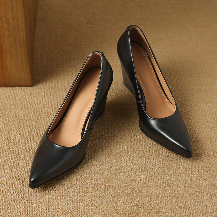 Black pointed-toe pumps with tan lining, pair view