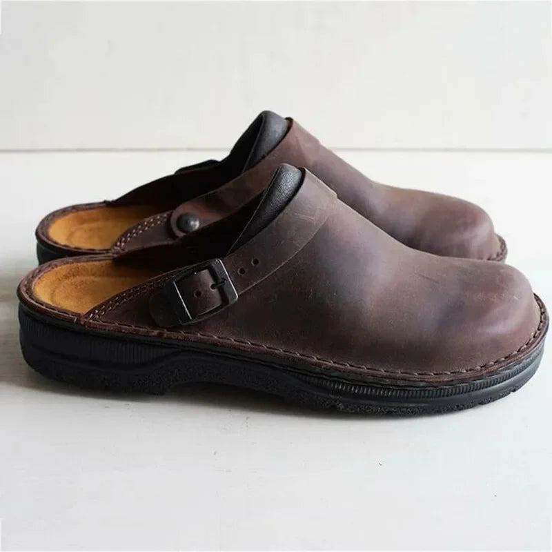 Brown leather slip-on clogs with buckle strap and cushioned black outsole