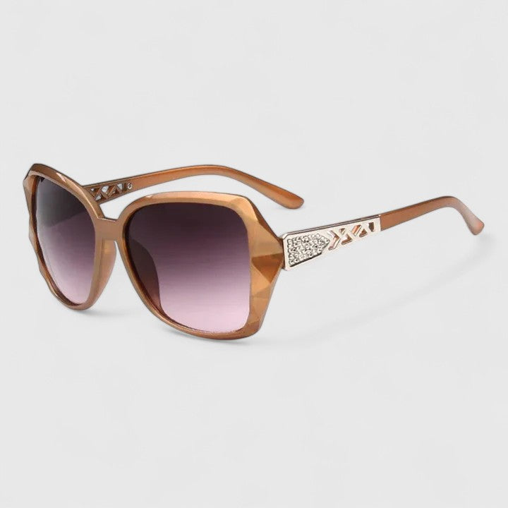 Champagne-framed sunglasses with dark purple tinted lenses and studded temple detail