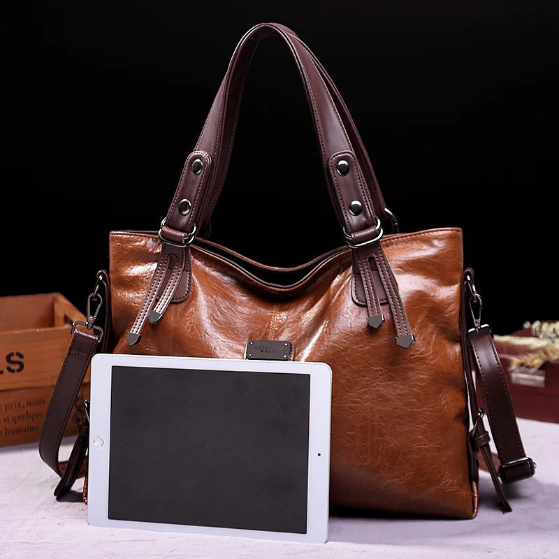 Brown soft leather tote bag with double handles and front logo patch