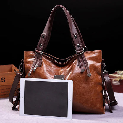 Brown soft leather tote bag with double handles and front logo patch