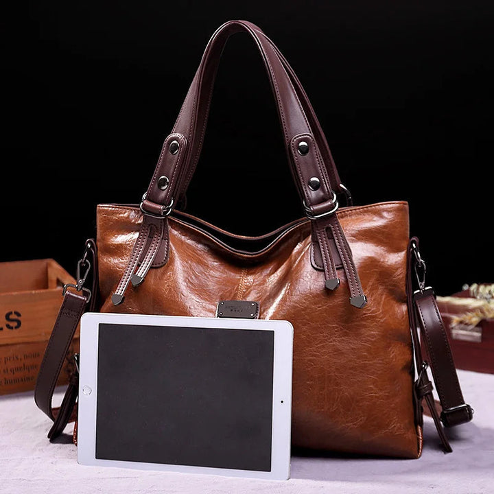 Brown soft leather tote bag with double handles and front logo patch