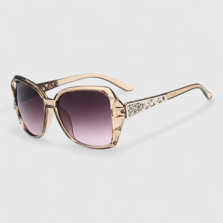 Gold framed sunglasses with dark purple tinted lenses and rhinestone-accented temple bar