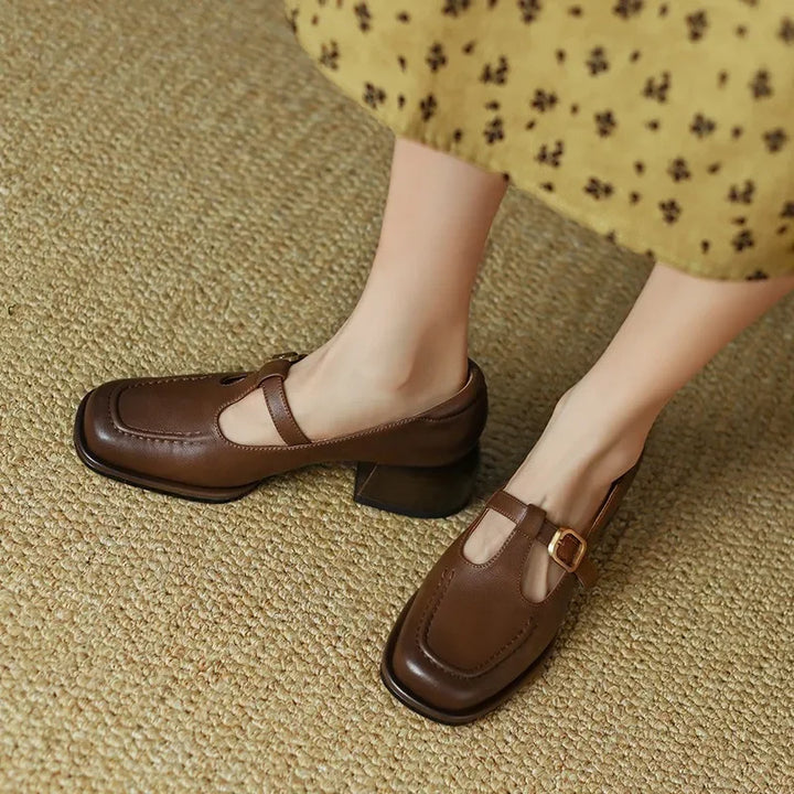 Brown T-strap loafer pair with chunky heel and buckle strap detail