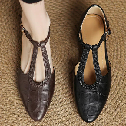 Black leather Mary Jane flats with braided strap trim and square metal buckle
