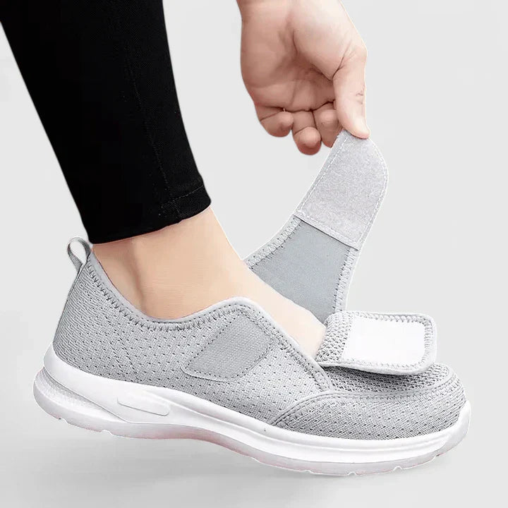 Gray orthopedic Velcro slip-on shoes, showing open hook-and-loop closure tab