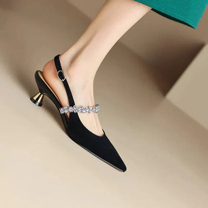 Black pointed-toe pumps with rhinestone strap and gold block heel