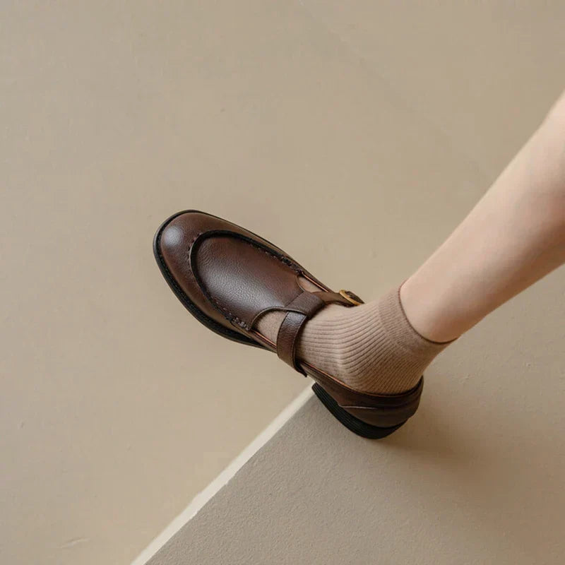 Brown retro slip-on shoe with cross strap and buckle detail, low block heel
