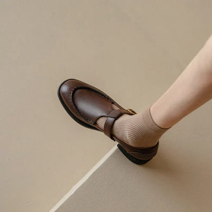 Brown retro slip-on shoe with cross strap and buckle detail, low block heel