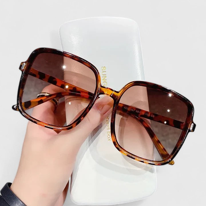 Elegant sunglasses with tortoiseshell brown frame and dark brown tinted lenses, square shape.