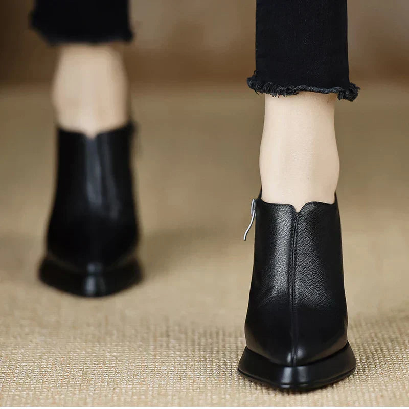 Black leather-look heeled pumps with back heel view and side zipper pull