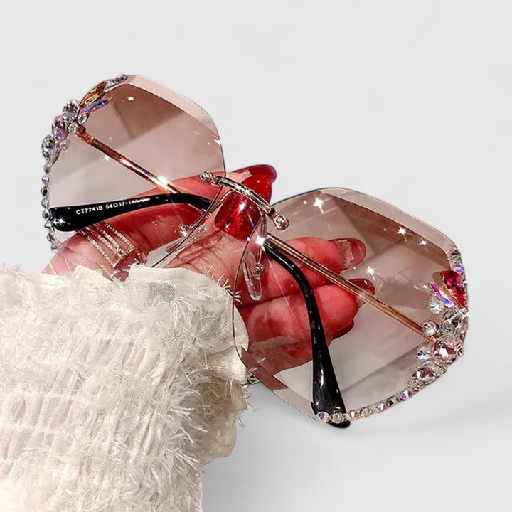 Jeweled sunglasses with large gradient lenses and rhinestone accents on frame