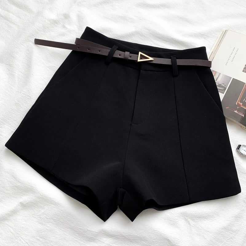 Black high-waist shorts with front crease and faux leather belt with gold buckle
