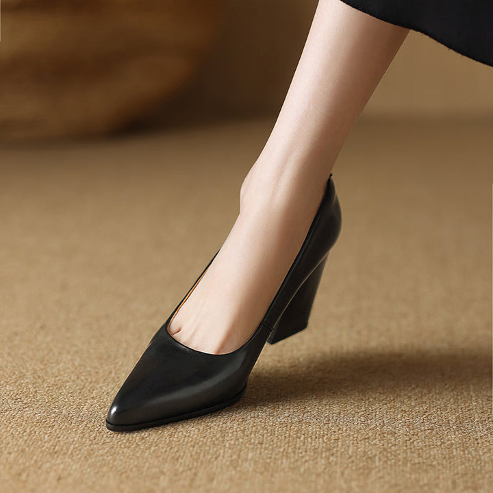 Black pointed-toe pumps with mid-height block heel, front view