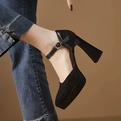 Black pumps with ankle strap buckle and thick block heel, side view