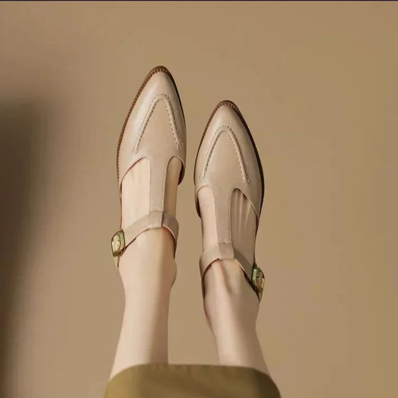 Pair of cream buckle shoes with side strap and low heel, stitched rounded toe