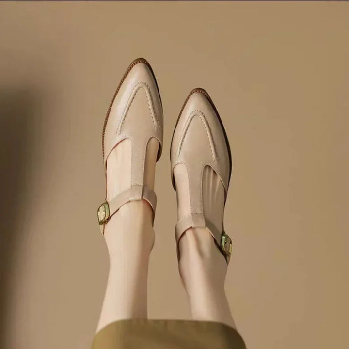Pair of cream buckle shoes with side strap and low heel, stitched rounded toe