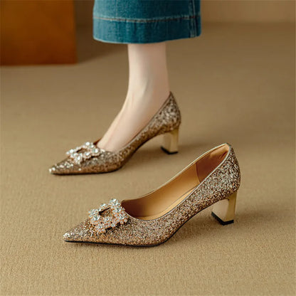 Gold-toned glitter pumps with pointed toe, jeweled bow, and mid-height block heels