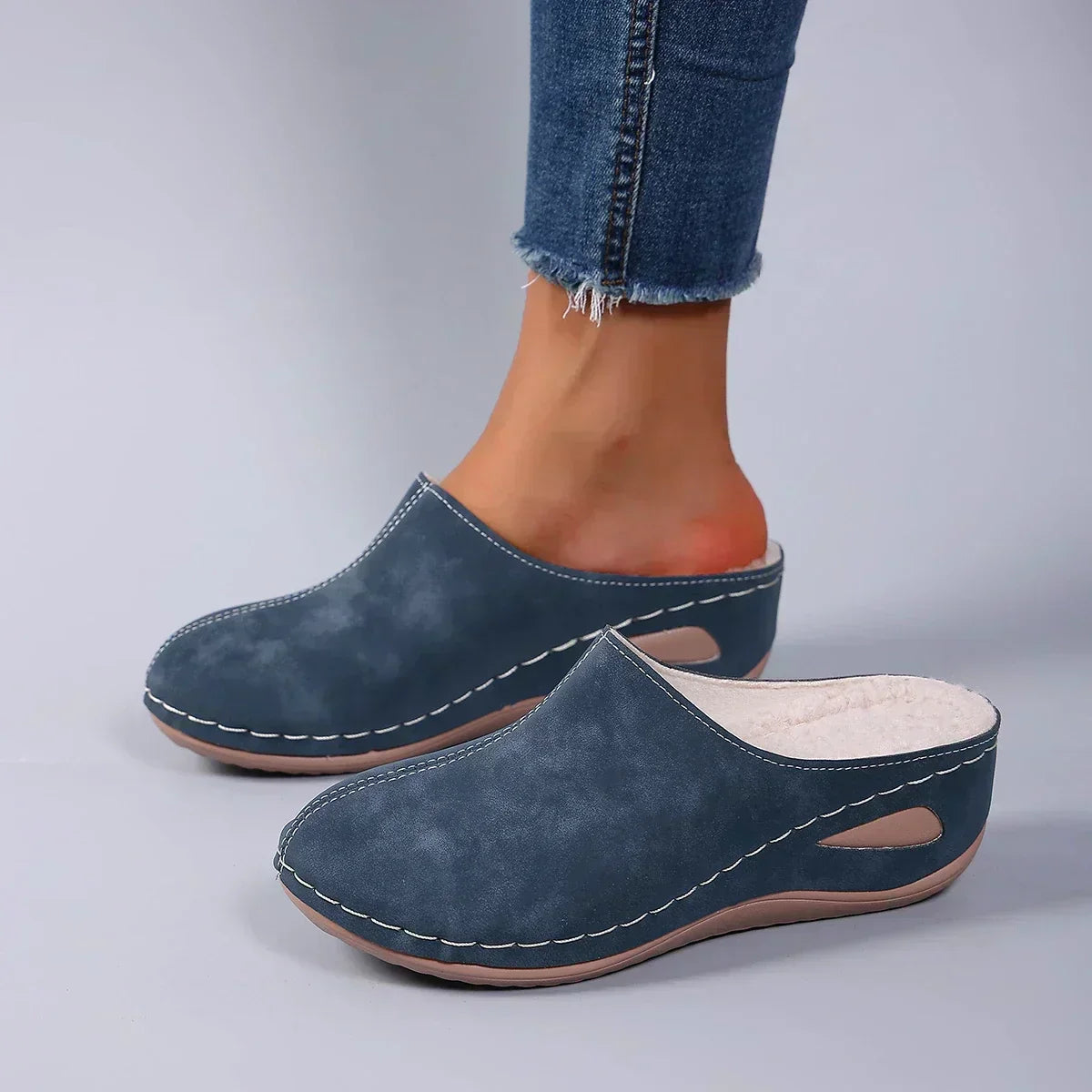 Blue orthopedic mules on model's feet, suede-like upper with cushioned lining