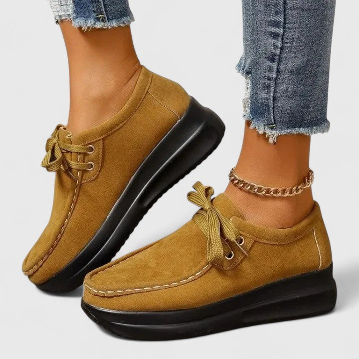Mustard lace-up orthopedic shoe with suede upper and thick black sole.