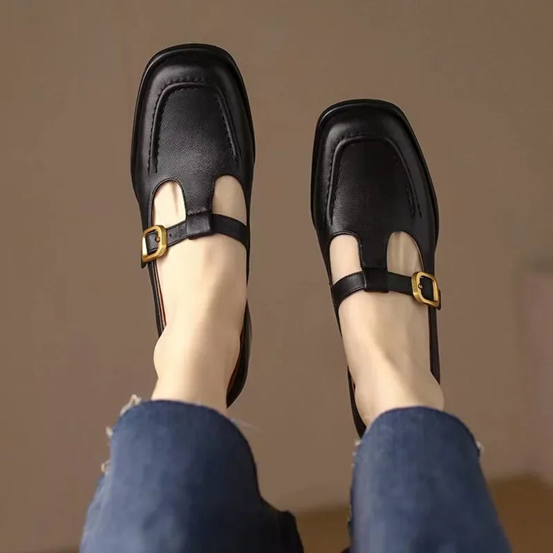 Black T-strap loafers with buckle strap and cutout on the front vamp
