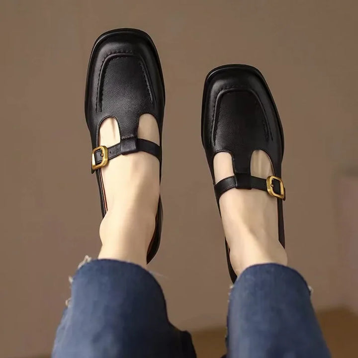 Black T-strap loafers with buckle strap and cutout on the front vamp