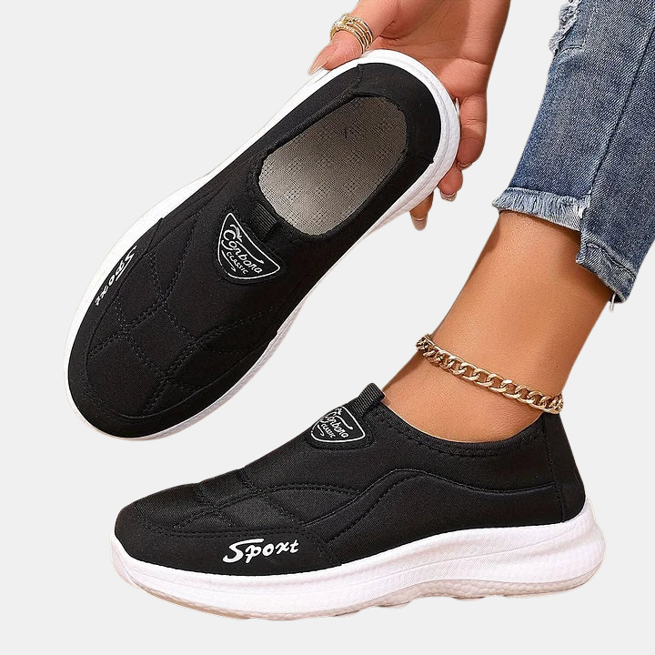 Black slip-on sneakers showing insole and heel with white midsole