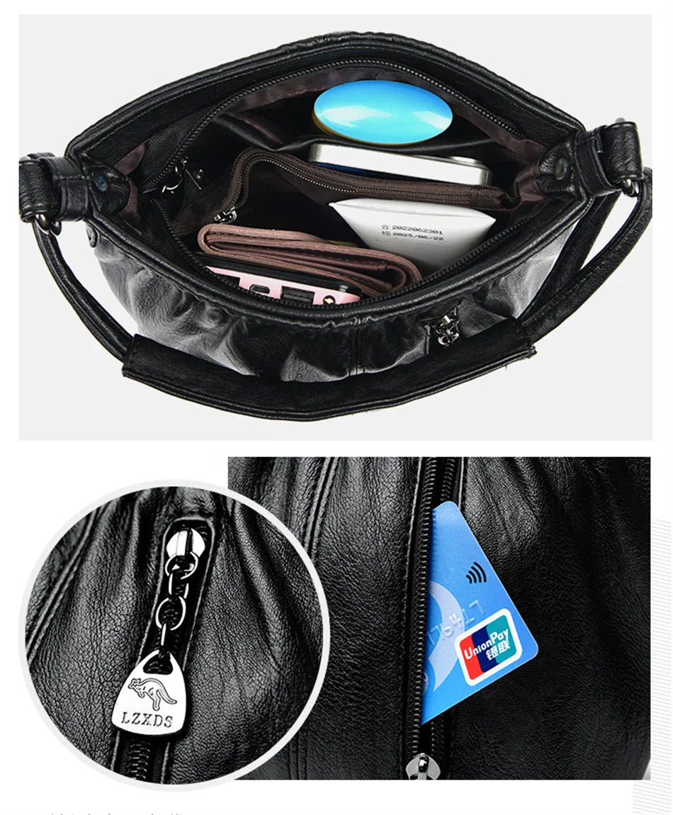 Black multi-layer handbag with zip pocket and metal zipper pulls; front charm detail