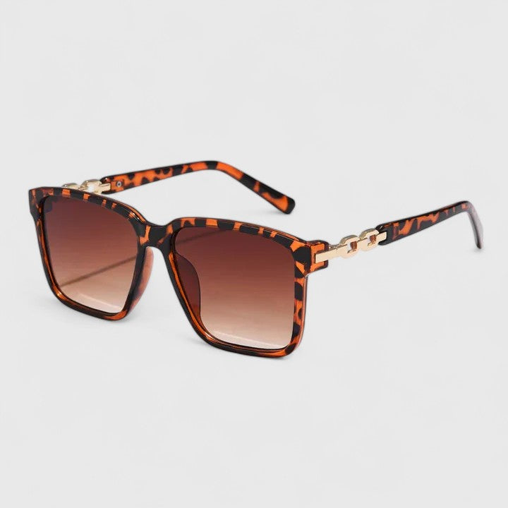 Square animal-print sunglasses with brown gradient lenses and gold chain bar detail