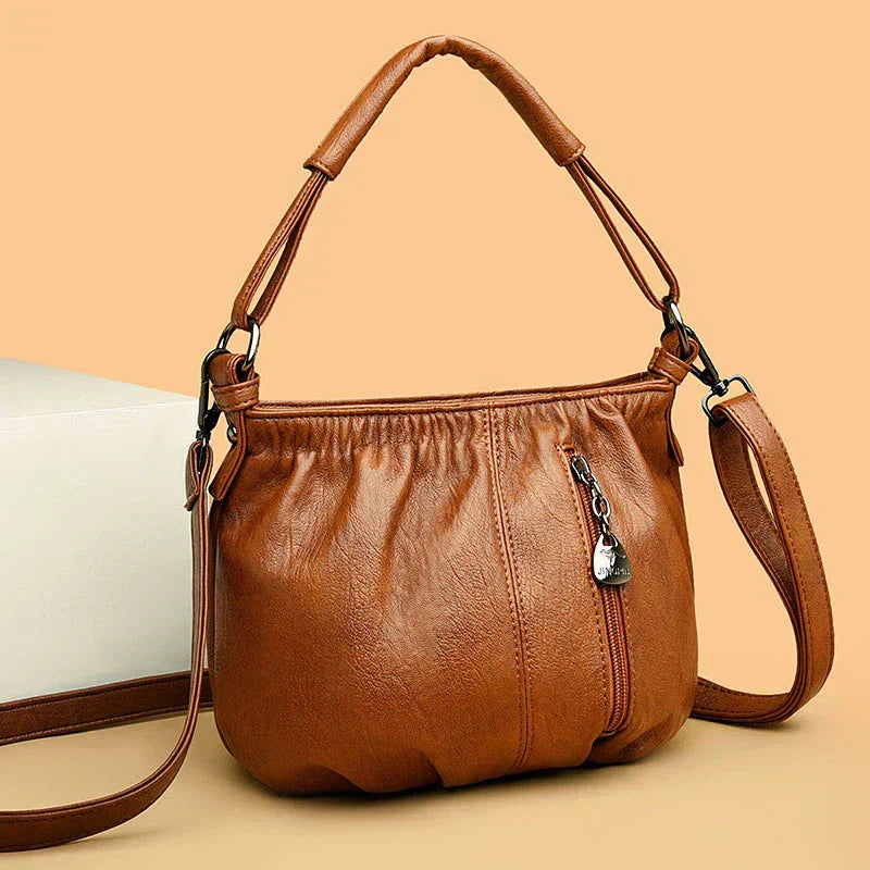 Brown multi-layer handbag with gathered front, top handles, and detachable shoulder strap