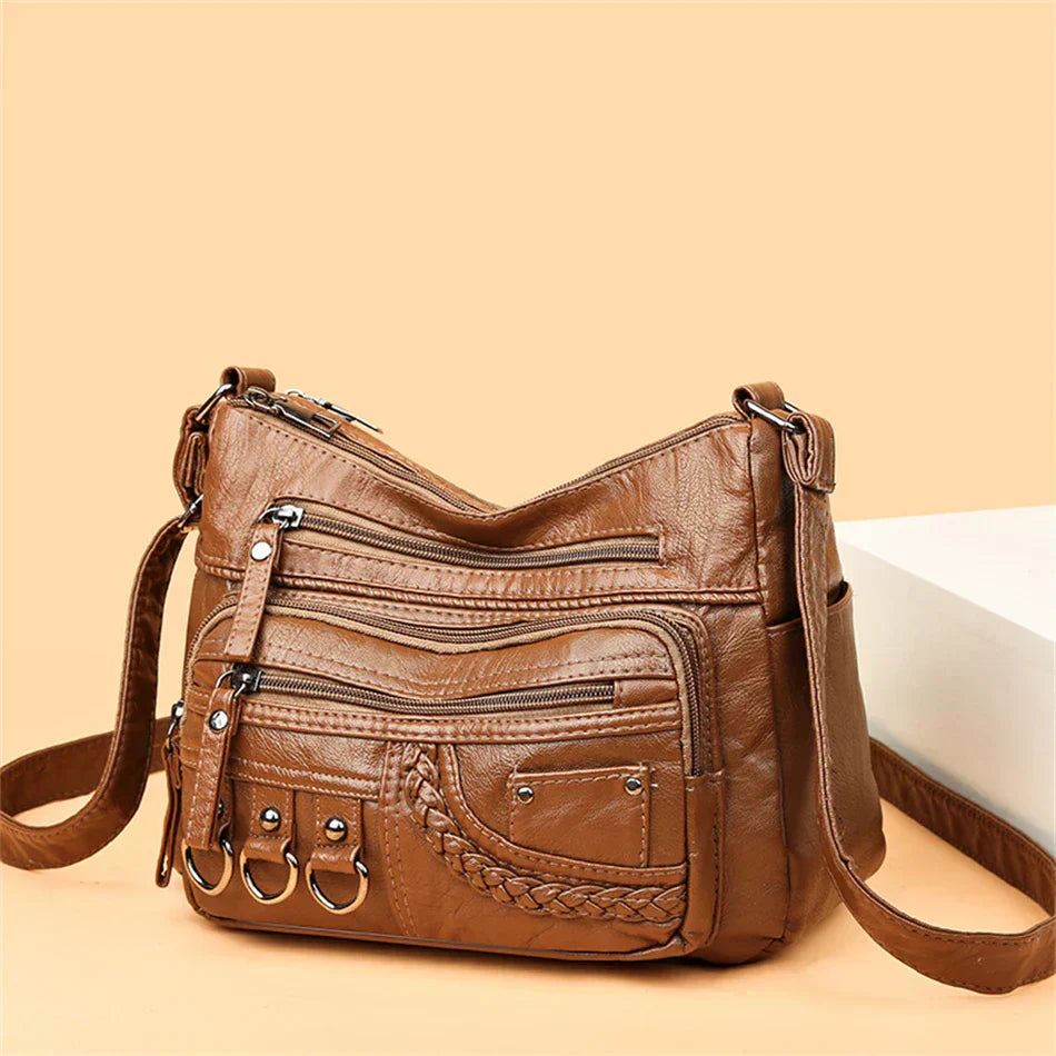 Brown multi-layer crossbody bag with crossbody strap and front zip pockets, braided detail