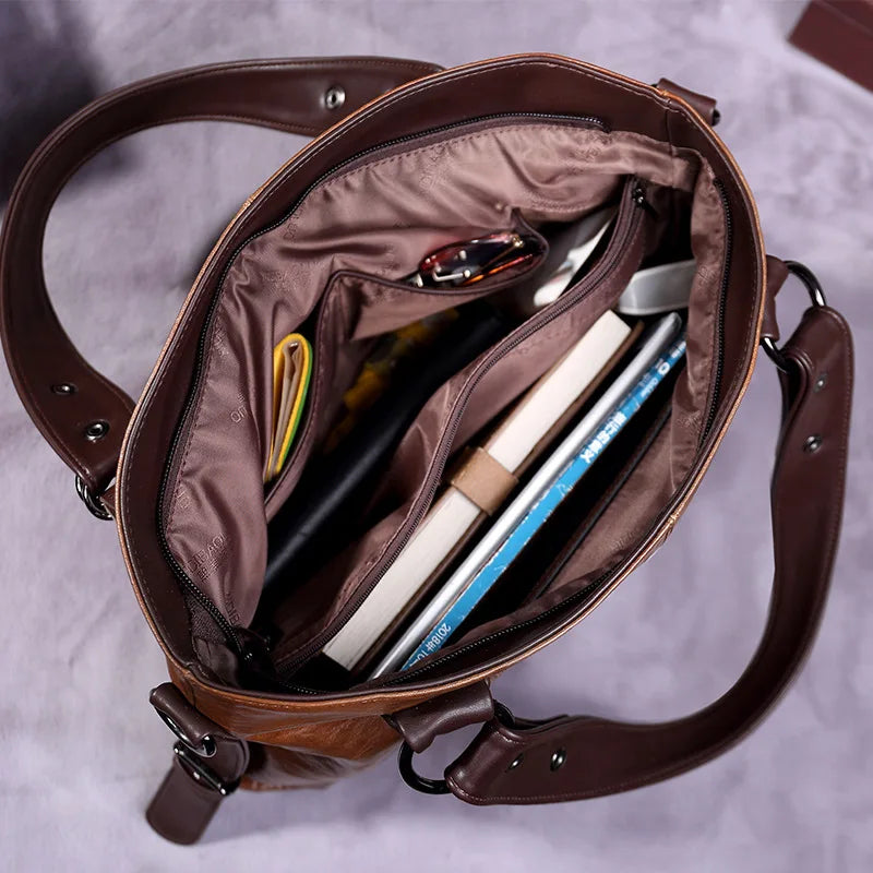 Open brown leather tote bag interior with zipper pocket and lined compartments