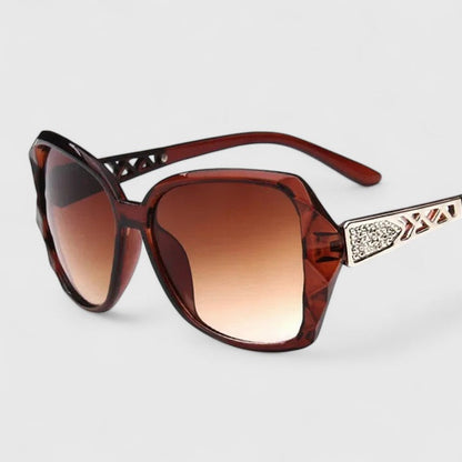 Burgundy framed sunglasses with dark tinted lenses and rhinestone-accented temple bar