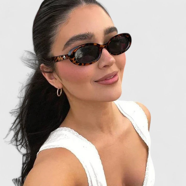 Tortoise oval sunglasses with dark lenses and rounded frames, side view on model