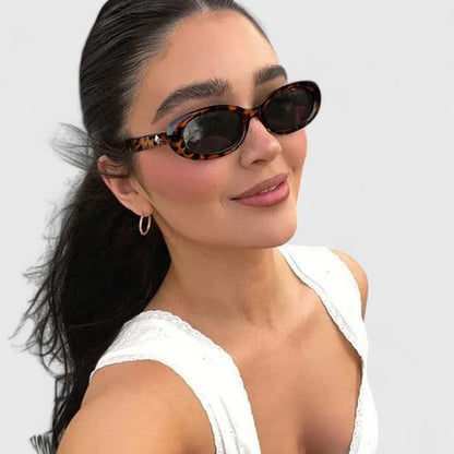 Tortoise oval sunglasses with dark lenses and rounded frames, side view on model