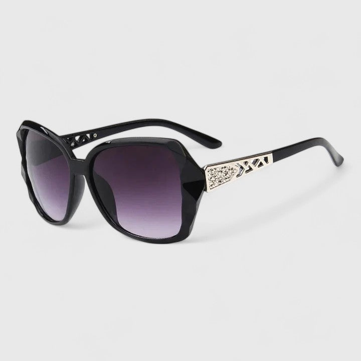 Black framed sunglasses with dark purple tinted lenses and rhinestone-accented temple bar