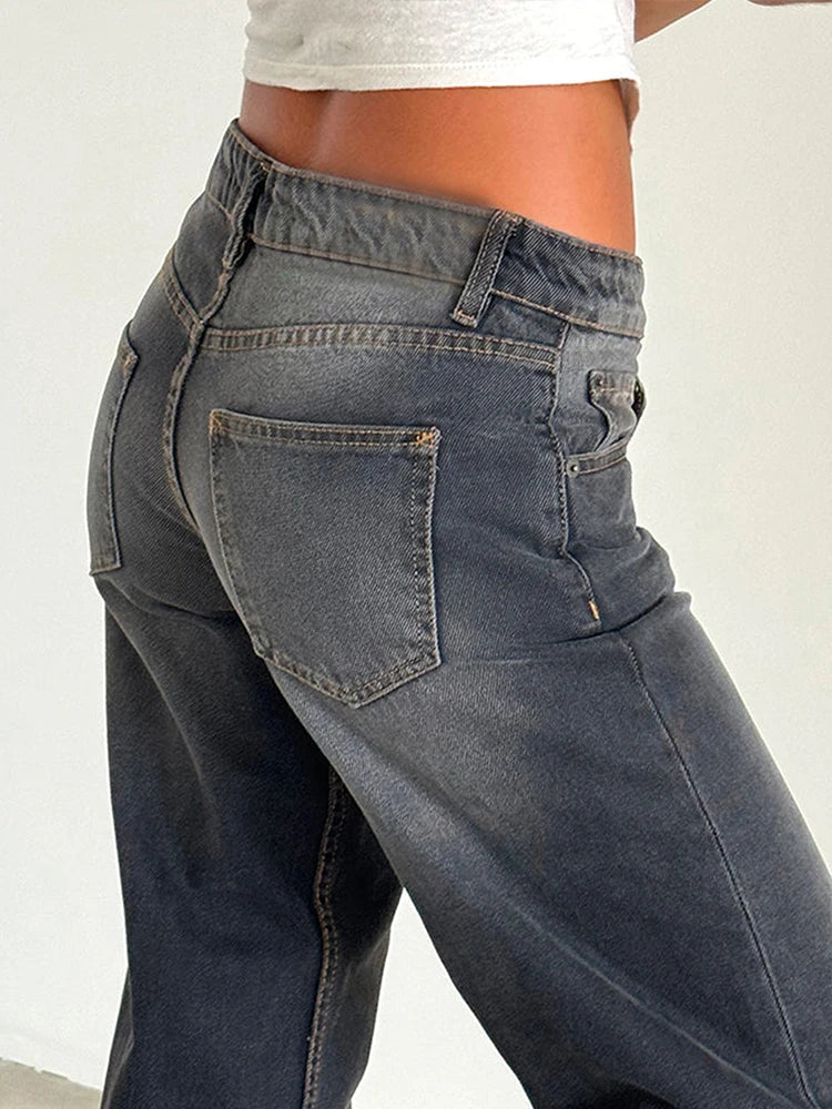 Washed gray baggy jeans close-up: high-rise waistband, belt loops, front button, flap pockets.