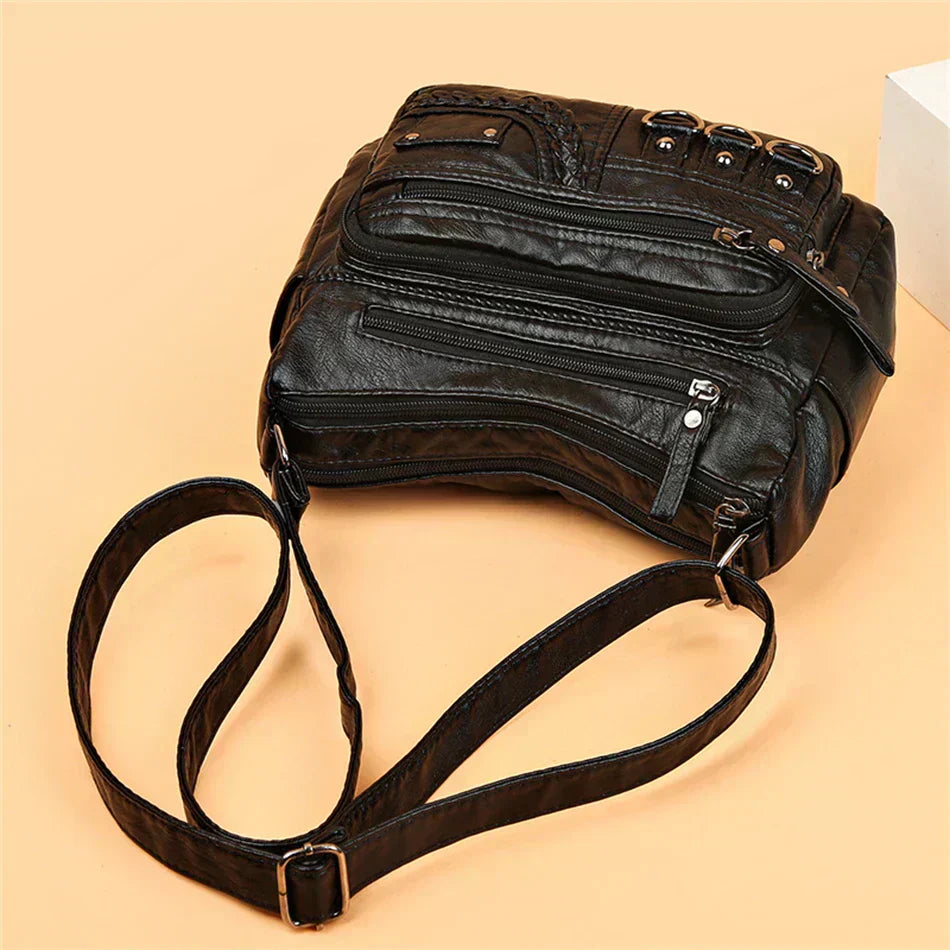 Black multi-layer crossbody bag with double straps and multiple zippered sections