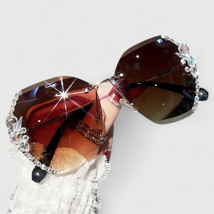 Jeweled sunglasses with gem-studded rims and dark red gradient lenses