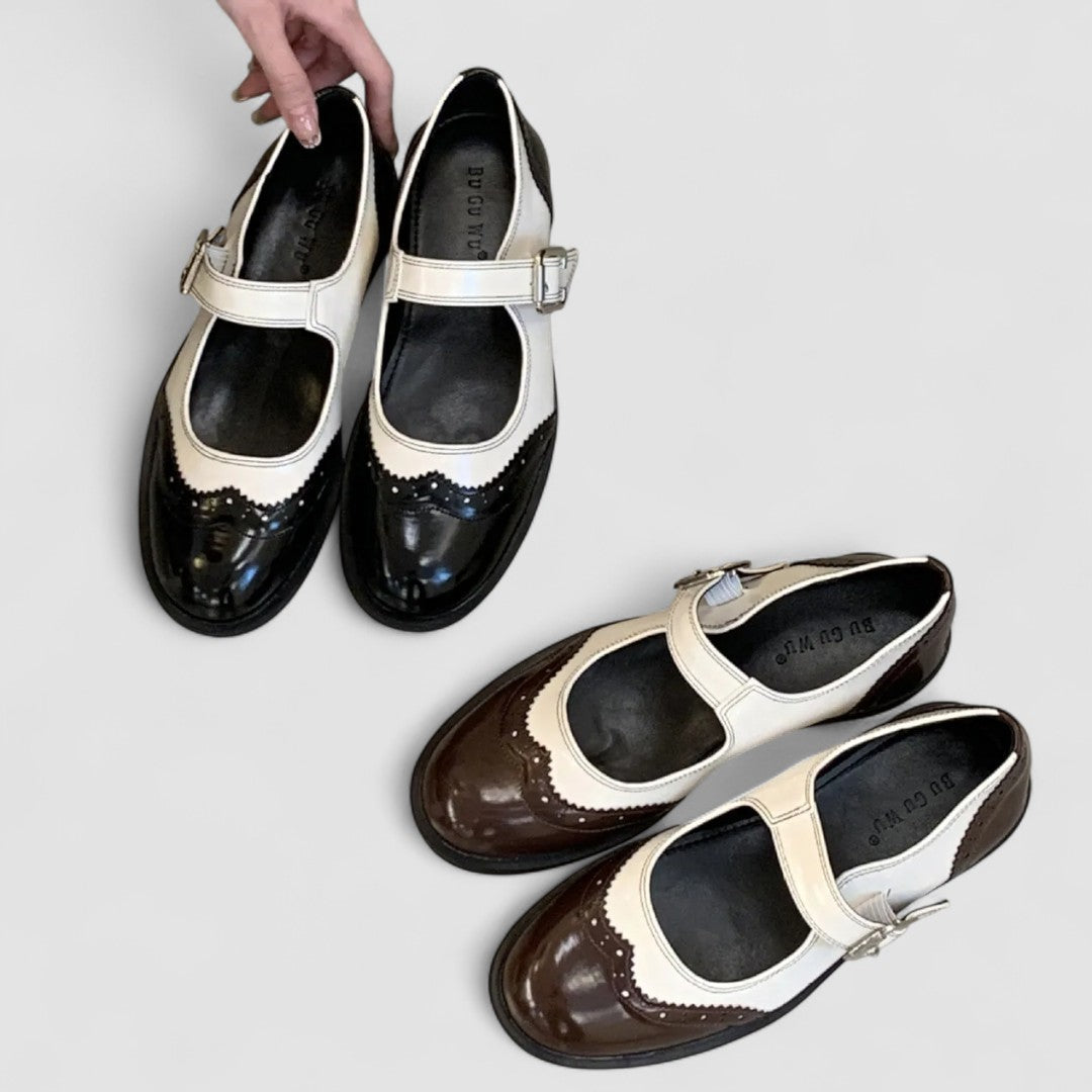 Pair of Mary Jane shoes in black and brown with cream straps and buckles