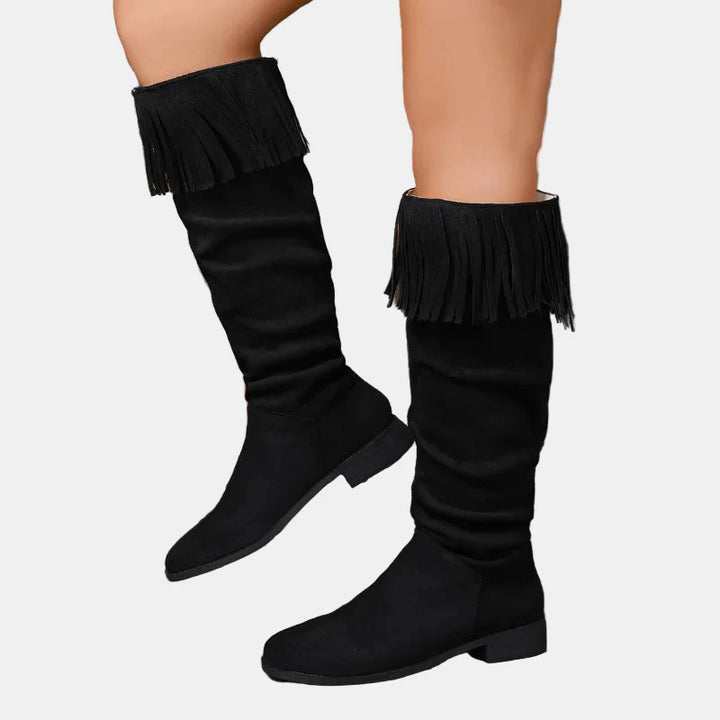 Black knee-high suede boots with fringed cuff and block heel.
