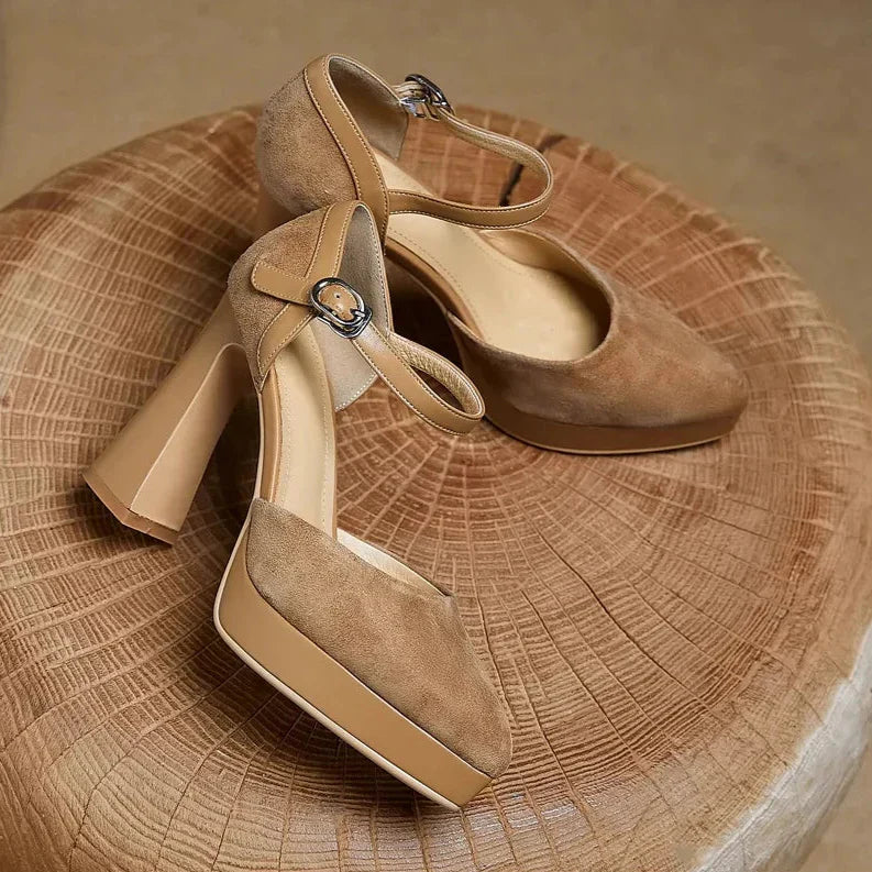 Brown suede pumps with ankle strap and buckle, closed-toe design, heel view
