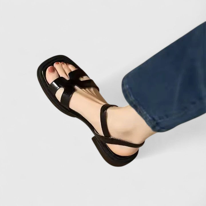 Flat thong sandals in black with buckled ankle strap and double band upper