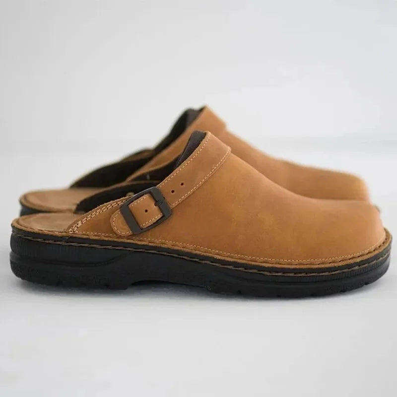 Tan leather slip-on clogs with strap buckle and stitched side panel