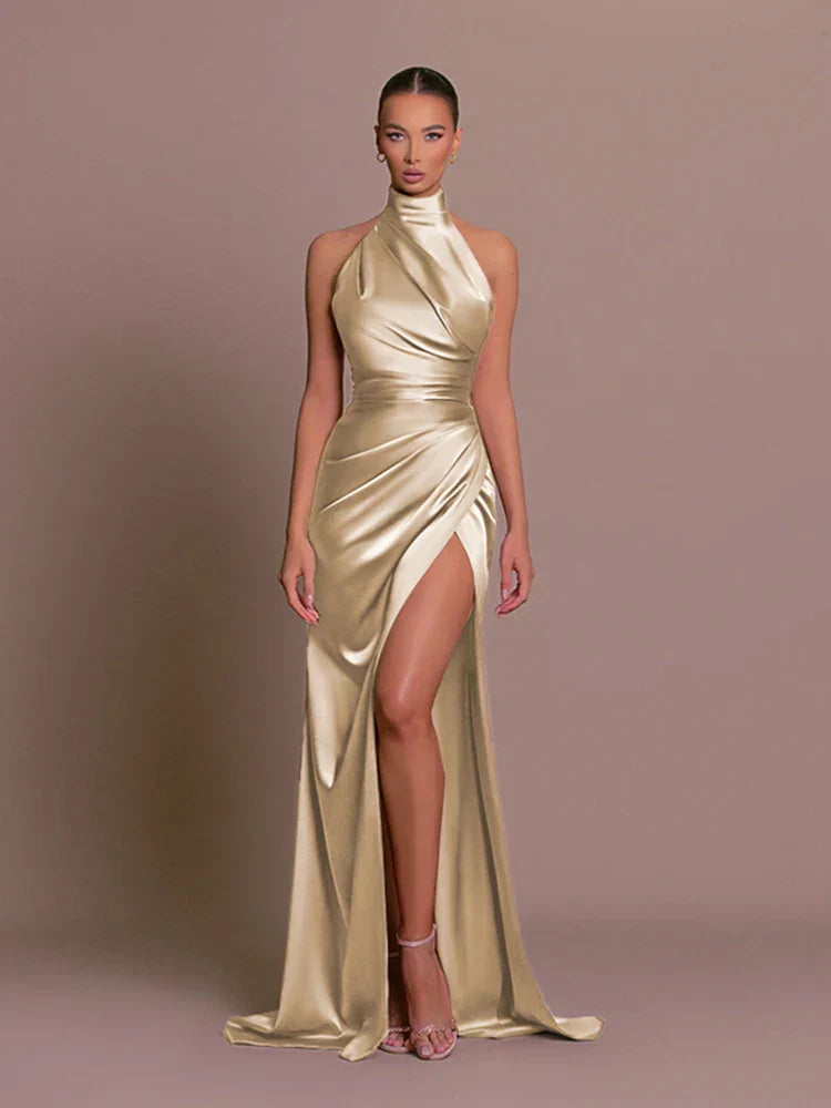 Gold satin side-slit maxi dress, halter neck, sleeveless with draped wrap front.